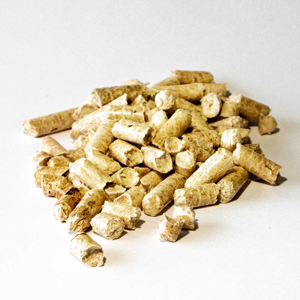 Stallpellets i lösvikt. Några pellets i en hög.